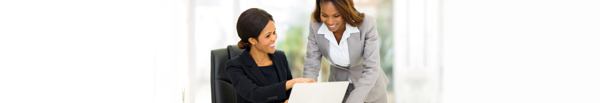 Two african business women working at the office on a computer